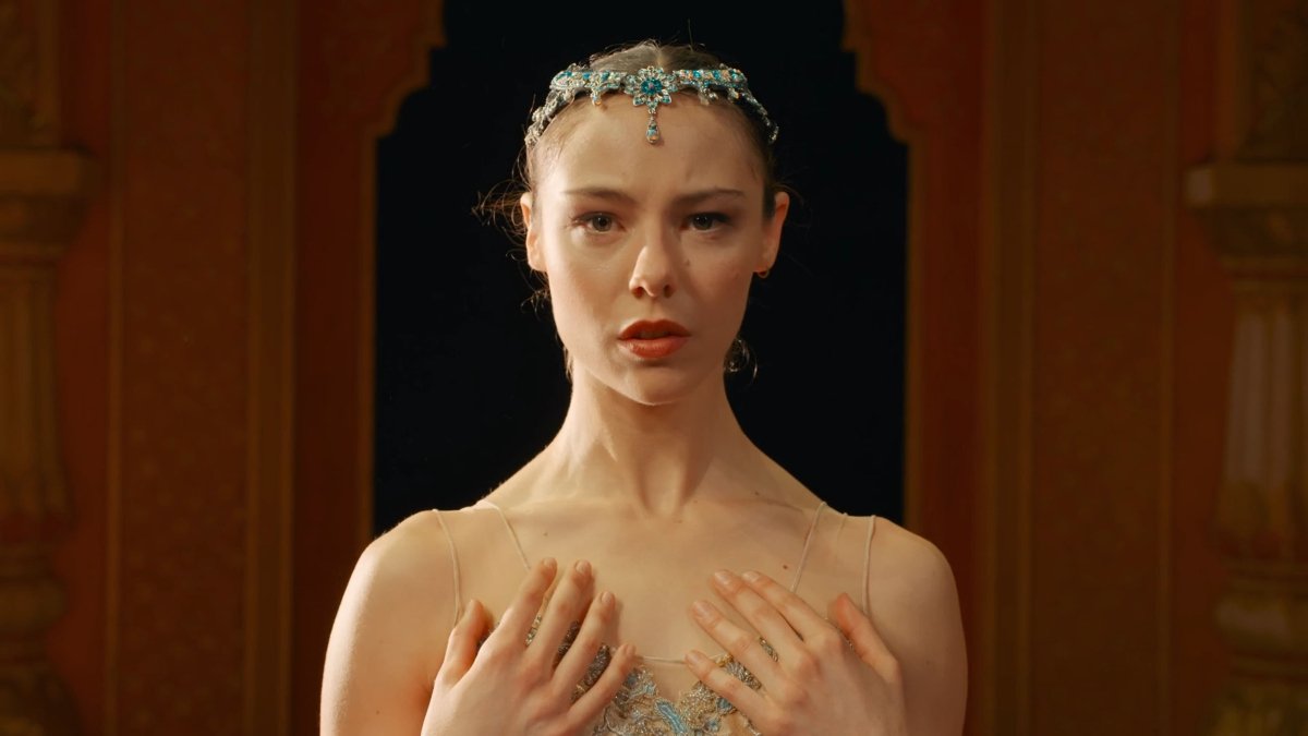 Danseuse de ballet jouée par Marion Barbeau dans le film En corps réalisé par Cédric Klapisch (2022) portant une couronne ornée, capturée en gros plan avec une expression émotive sur scène, dans une ambiance théâtrale.