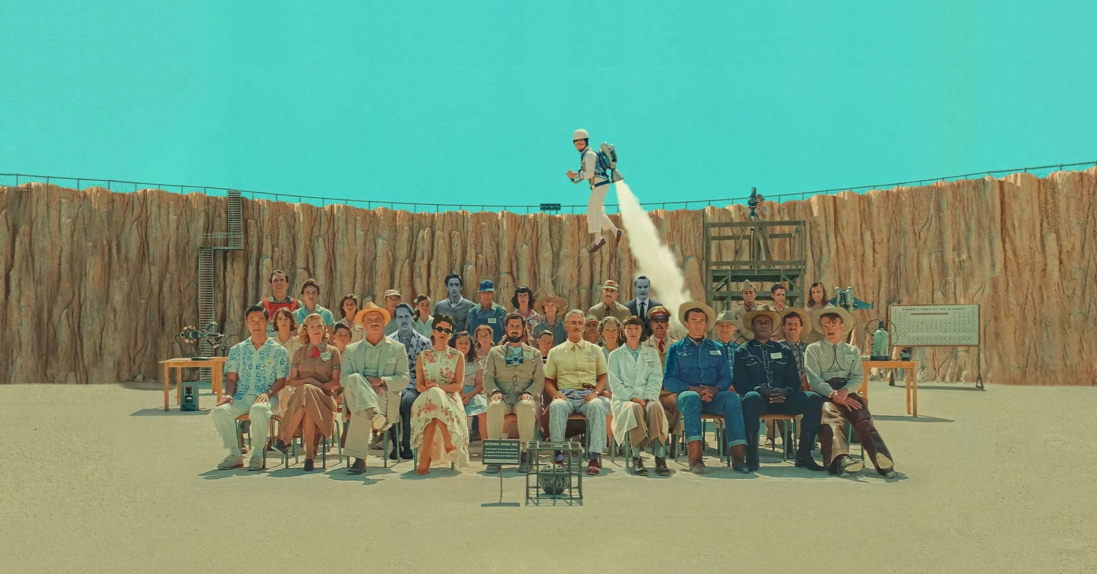 Critique Asteroid City : ensemble du casting en photo de classe dans le film (2023) de Wes Anderson.