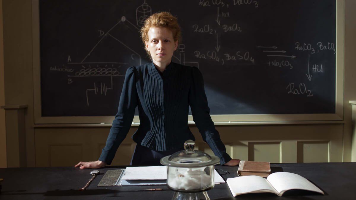 Karolina Gruszka dans le rôle de Marie Curie, à son bureau devant un tableau noir, dans le film Marie Curie (2016) de Marie Noëlle.