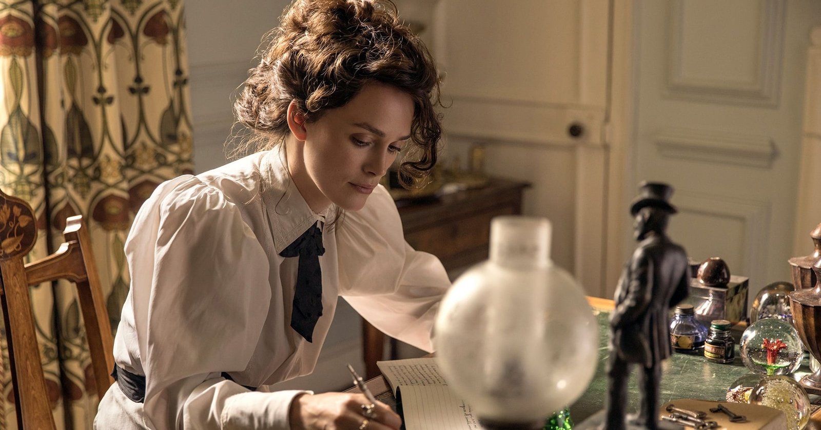 Keira Knightley écrivant à son bureau, dans le film Colette de Wash Westmoreland.