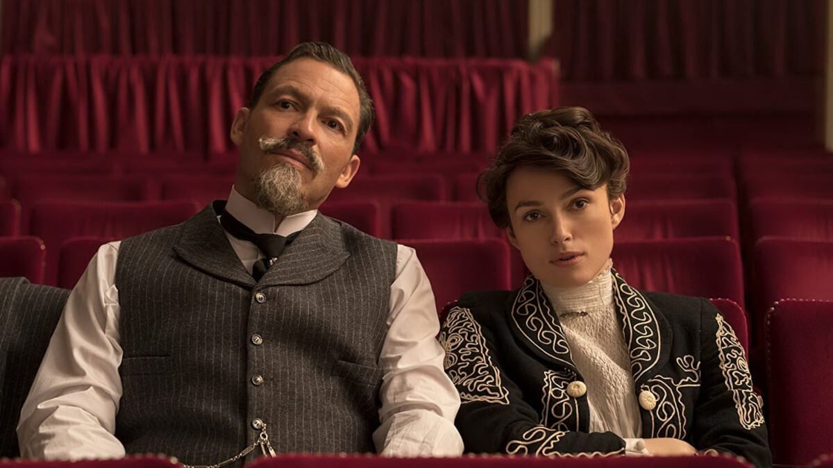 Keira Knightley et Dominic West assis dans des sièges de théâtre rouge, dans le film Colette de Wash Westmoreland.